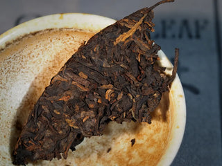 Spring Ming Ripe Pu-erh Tea Cake (2008 Commemoration) – Menghai, Yunnan single piece steeped in a gaiwan, revealing deep ruby-red liquor emerging from rich leaves.