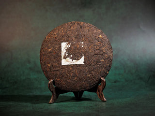 Bare front side of Spring Ming Large 400g Menghai Ripe Pu-erh Tea Cake – 2020 showing tightly compressed tea leaves.