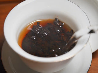 Second infusion of the Spring Ming Large 400g Menghai Ripe Pu-erh Tea Cake – 2020 with hot water being poured into the gaiwan.