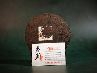 Unwrapped Spring Ming 400g Menghai Ripe Pu-erh Tea Cake – 2020 displayed with the product information card beside it.